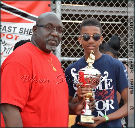 Bomb Tune Competition winner ADLIB Steel Orchestra’s representative receives prize trophy from USSA president Keith Marcelle