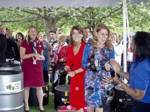 Princesses Eugenie (center, in red with maracas) and Beatrice (second from right with tambourine) and SV2G Wycombe Steel Orchestra