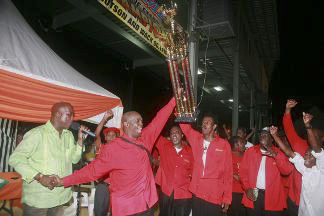 Witco Desperadoes interim captain David Davis holds aloft the Pillars of Steel Best Repertoire Trophy to fellow players who celebrate after the Laventille steelband was adjudged winner of the competition. At left is producer Junior Hutson who presented the trophy