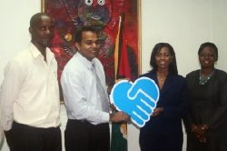 Republic Bank Limited Branch Support Service Manager, Celine Davis hands over the cheque to Culture, Youth and Sport Minister Dr Frank Anthony