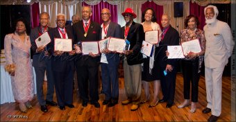 Honored Steelband pioneers and proxies hold awards at the end of the evening