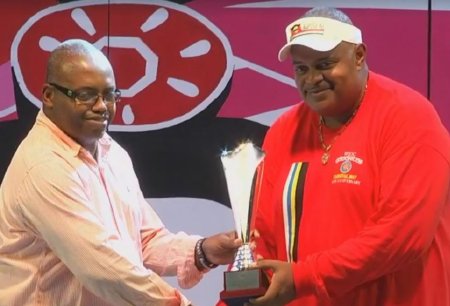 National Festivals Commission Chairman Maurice Merchant presents representative of Gemonites Steel Orchestra with third-place trophy