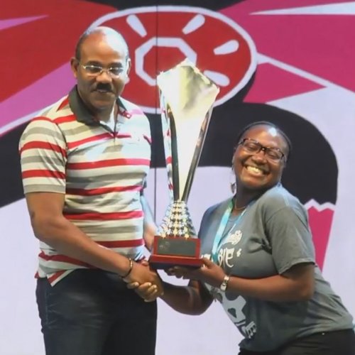 Hells Gate Steel Orchestra musician happily receives 2017 Panorama Championship trophy from Antigua & Barbuda Prime Minister Gaston Browne